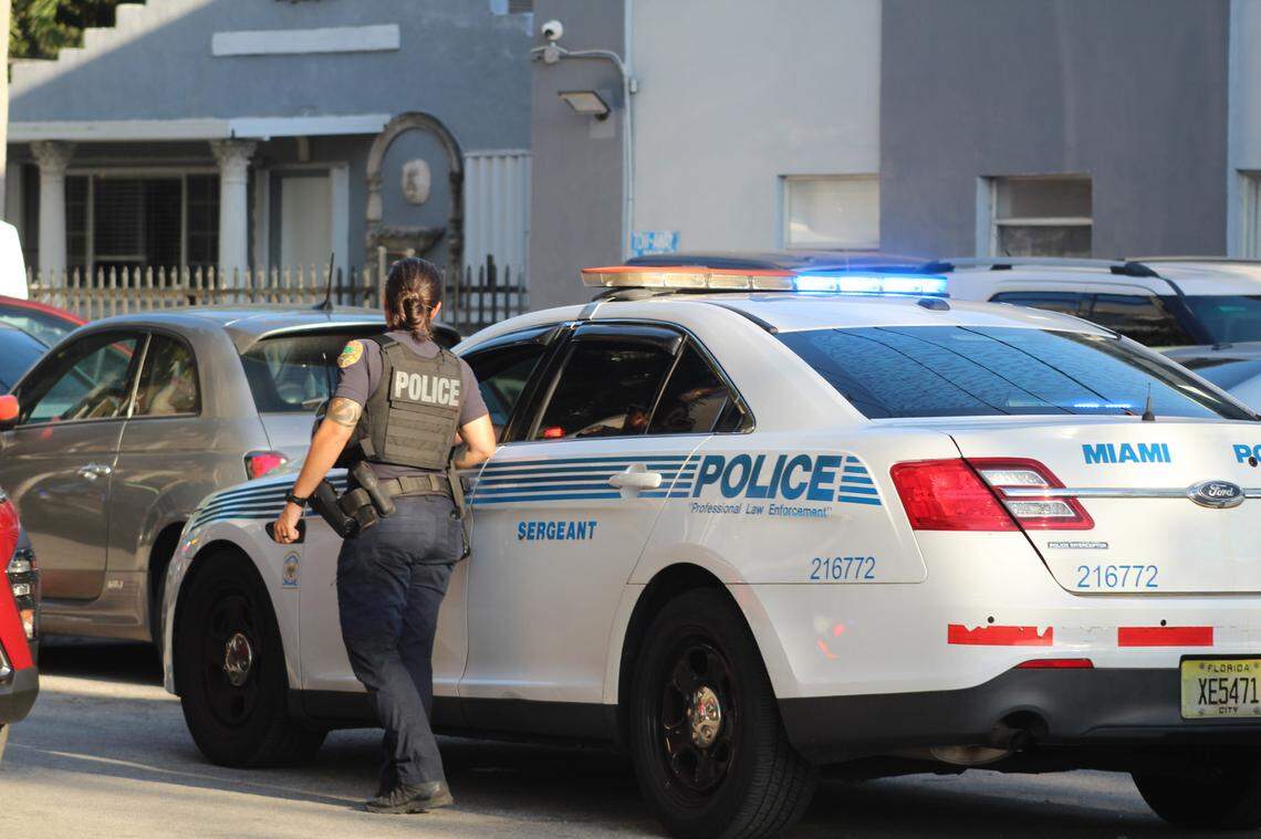 Miami police officers gather outside the Miami Riverfront Residences at 2601 NW 16th Street Road Wednesday, May 7, 2025. Police helped Suffolk County Police detectives conduct a search warrant at a unit there in connection with a Long Island homicide.