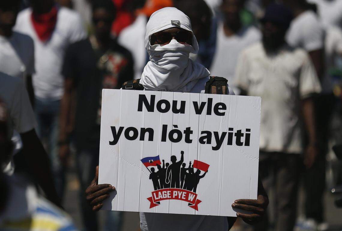 A demonstrator carries the Creole message “We want a different Haiti” during a march led by the art community to continue demanding the resignation of Haitian President Jovenel Moise in Port-au-Prince, Haiti, Sunday, Oct. 13, 2019. Protests have paralyzed the country for nearly a month, shuttering businesses and schools.