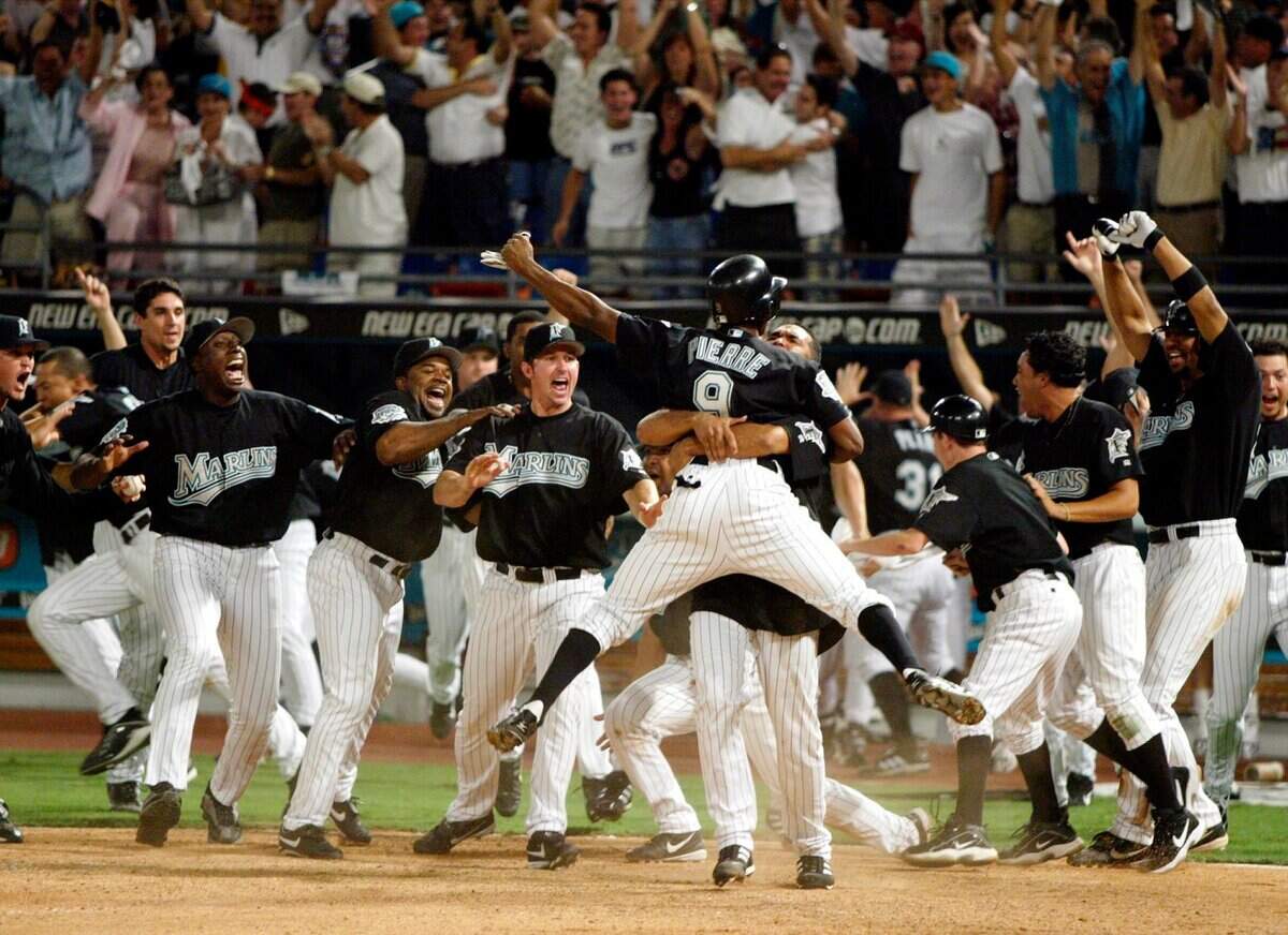 Juan Pierre is greeted by teammates after scoring the winning run in the 11th inning against Giants Friday Oct 3, 2003.