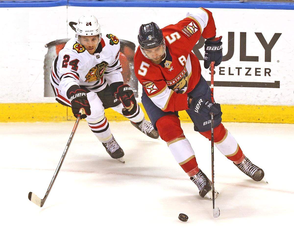 Florida Panthers Aaron Ekblad (5) and Chicago Blackhawks Pius Suter (24) in the second period at the BB&T Center in Sunrise, Florida, Monday, March 15, 2021.