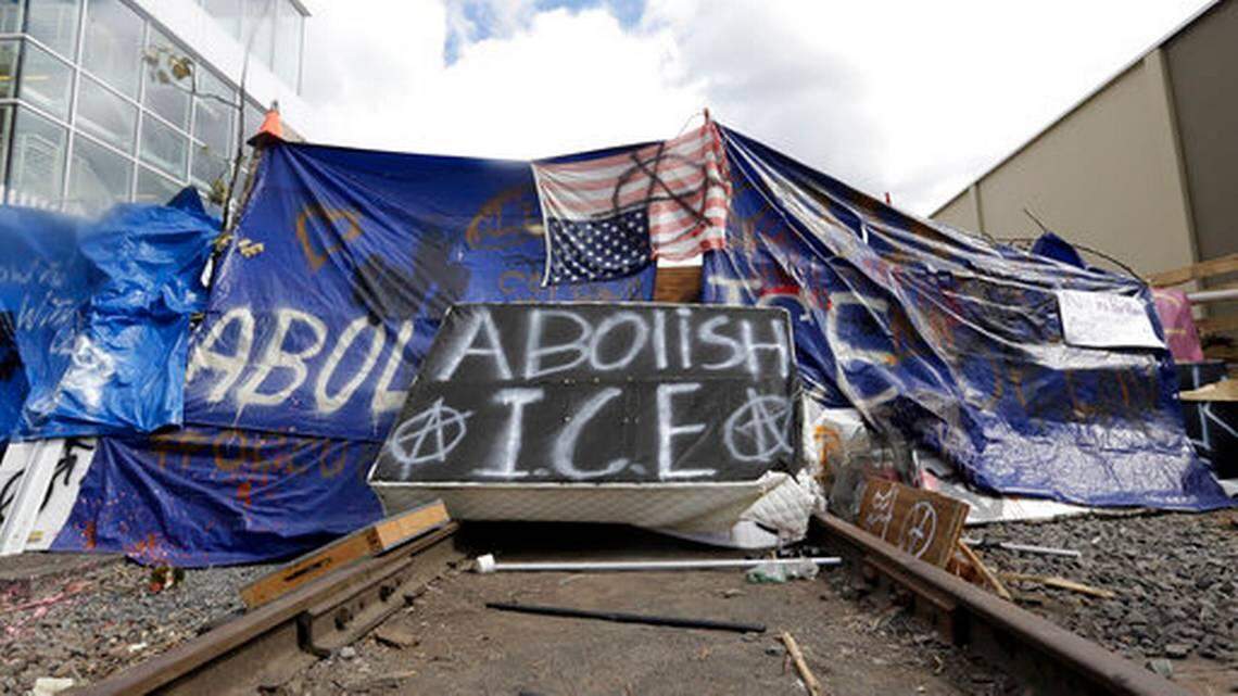 A barricade crosses railroad track at a protest camp on property outside the U.S. Immigration and Customs Enforcement office in Portland, Ore., Monday, June 25, 2018.