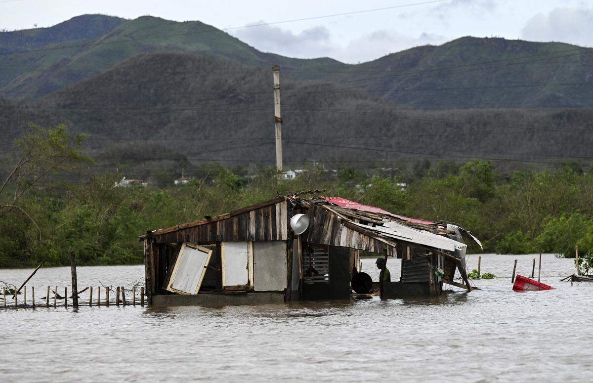 A farmer remains inside his flooded house after the passage of Hurricane Melissa through the town of San Miguel de Parada in Santiago de Cuba province on October 29, 2025. A powerful Hurricane Melissa made landfall in eastern Cuba on Wednesday, causing damage and flooding to homes and streets in Santiago de Cuba province, an AFP team on the ground reported. 