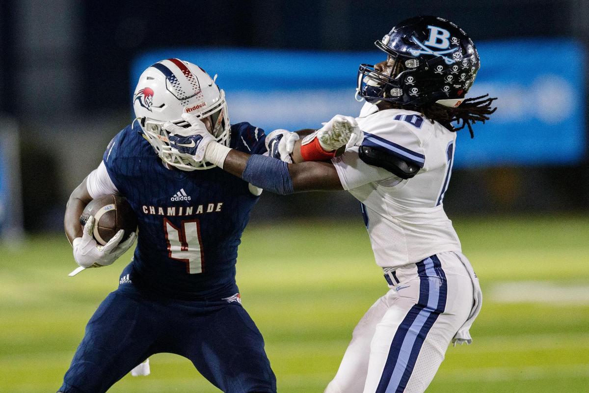 Chaminade-Madonna’s Edwin Joseph (4) pushes off a defender as he runs the ball down the field. Chaminade-Madonna leads Berkeley Prep 7-0 at the half of the 3A State Championship game at Gene Cox Stadium on Friday, Dec. 10, 2021.