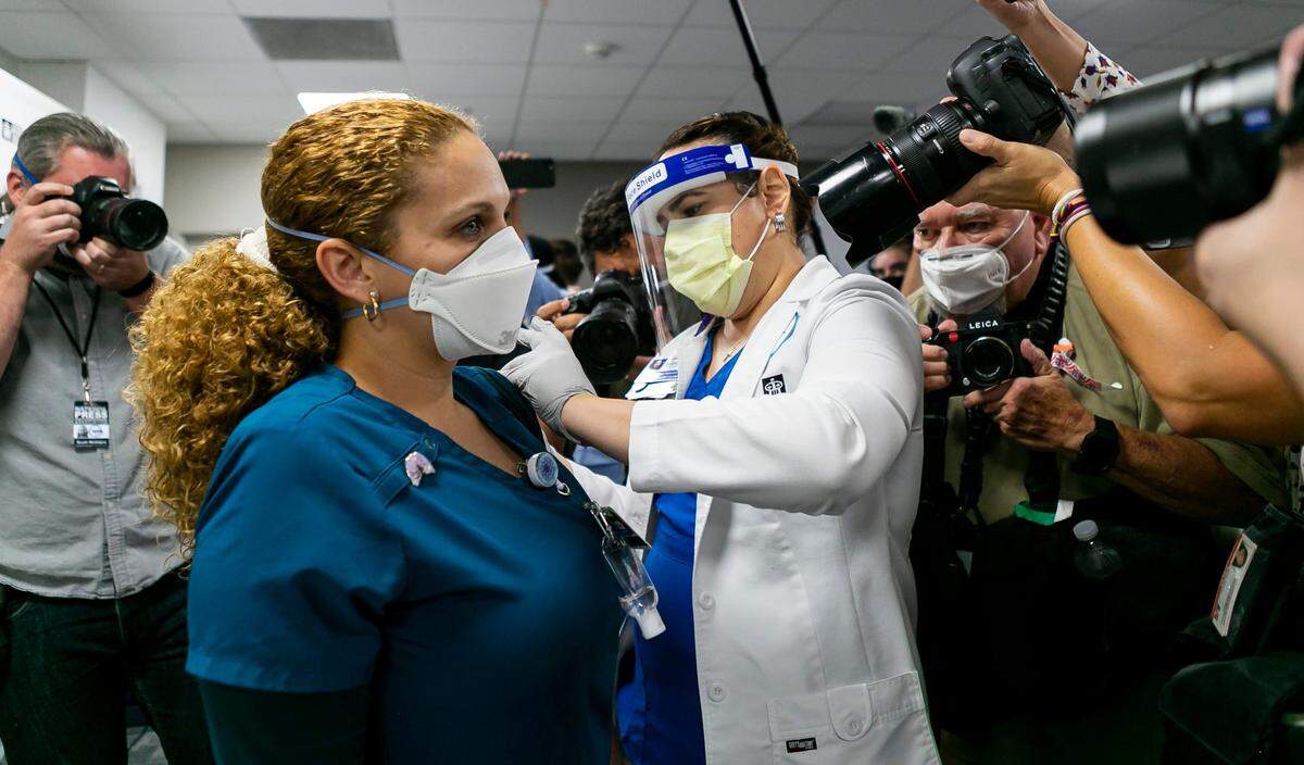 Respiratory Therapist Elizabeth Plasencia receives the Pfizer-BioNTech COVID-19 vaccine at Jackson Memorial Hospital in Miami, Florida, on Tuesday, Dec. 15, 2020.