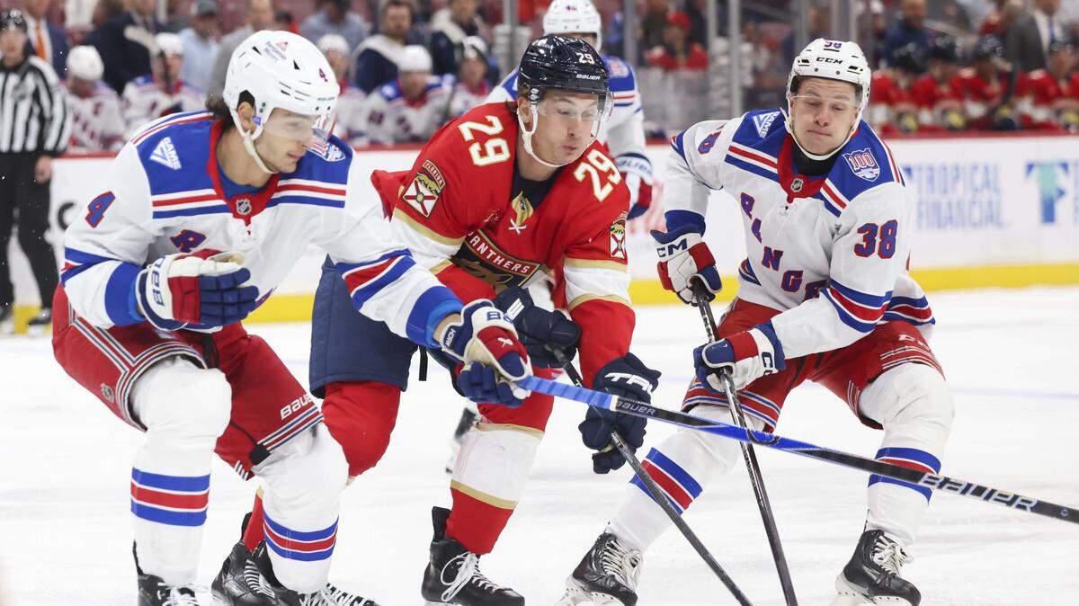 Florida Panthers left wing Cole Reinhardt (29) fights for the puck against New York Rangers defenseman Braden Schneider (4) and left wing Adam Sykora (38) during the first period of a game on Monday, April 13, 2026, at Amerant Bank Arena in Miami, Fla.
