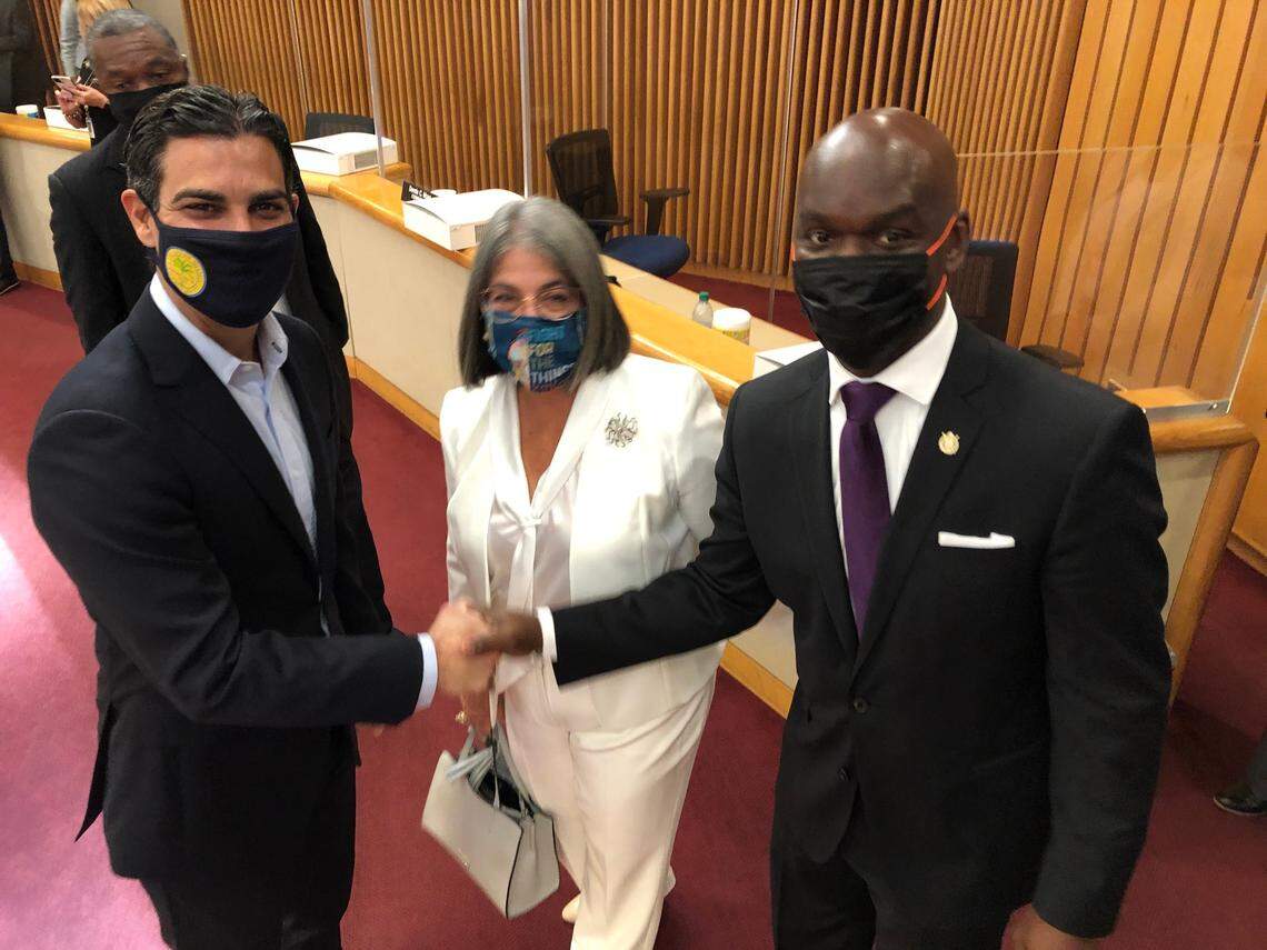 Miami Mayor Francis Suarez, left, greets new County Commissioner Kionne McGhee, right, and Miami-Dade Mayor Daniella Levine Cava stands between them on her first day in office, Tuesday, Nov. 17, 2020. They were photograhed in the County Commission chambers, where McGhee took the oath of office as the new District 9 commissioner.