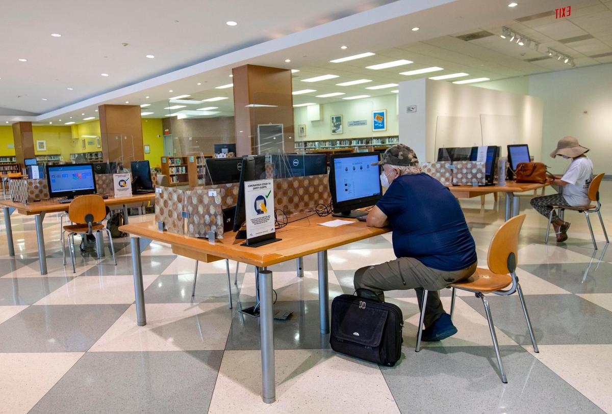 People use the free computers to surf the internet as well as apply for and update their unemployment status at Hispanic Branch Library in Miami, Florida on Tuesday, July 21, 2020.