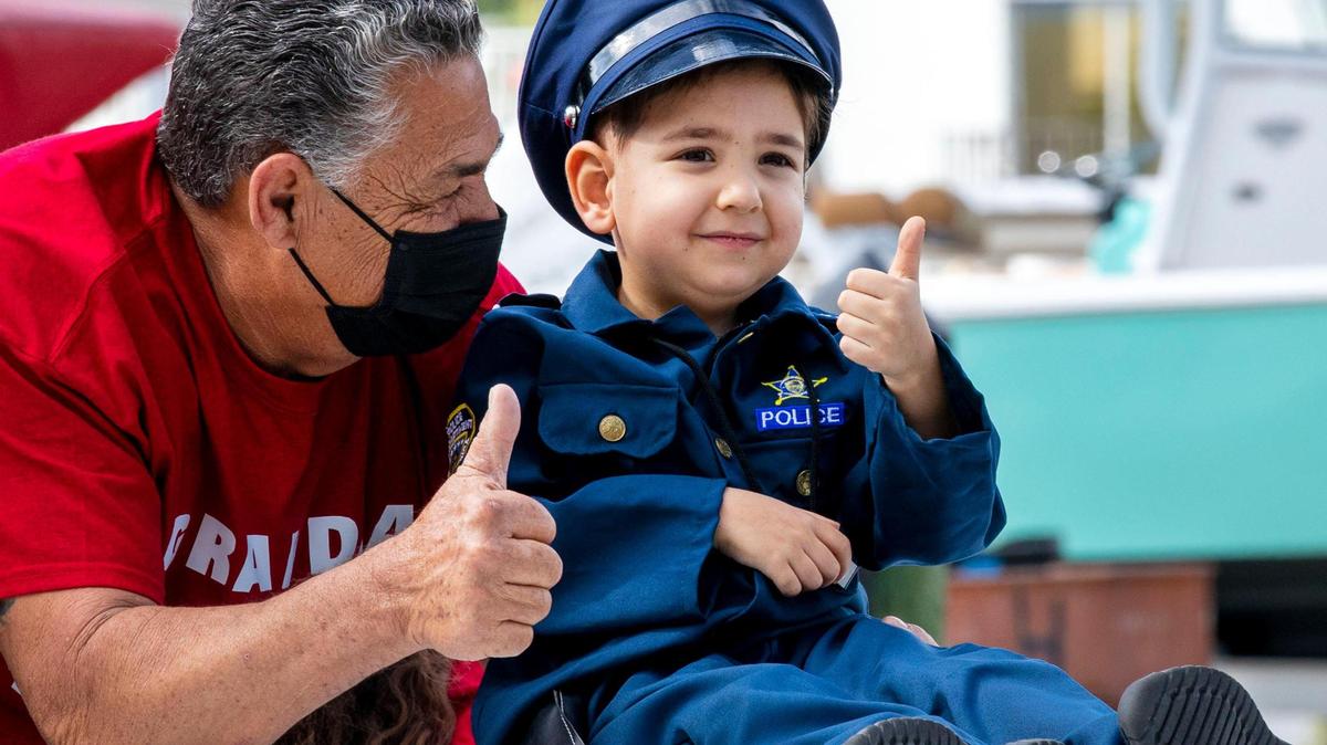 Kayson Roman, 6, has been fighting cancer since the age of 1, gives a thumbs-up next to his grandpa Alfredo Diaz, while riding in the North Miami police boat police boat on Friday, January 7, 2022. Multiple South Florida law enforcement agencies granted a special wish for ˜Captain Kayson” during an event coordinated between the Mystic Force Foundation and North Miami Police.