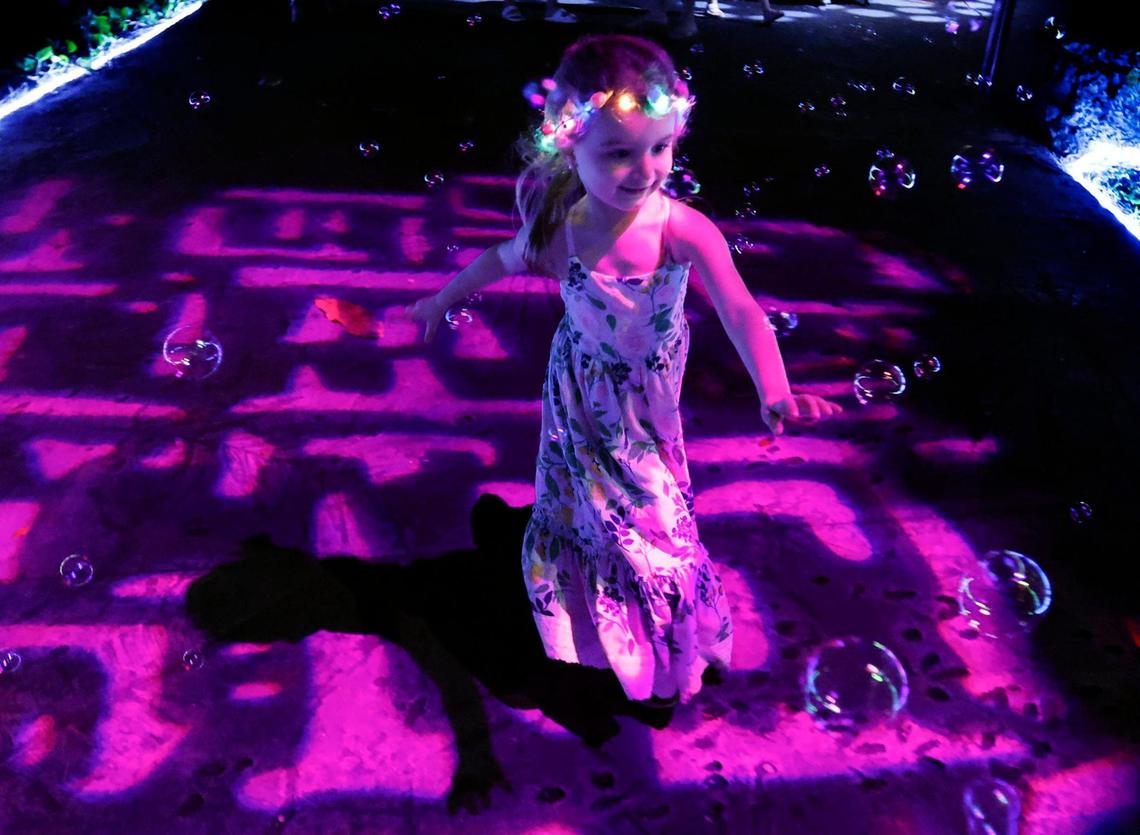 Lucia Motes, 3, chases bubbles along the path at NightGarden.
