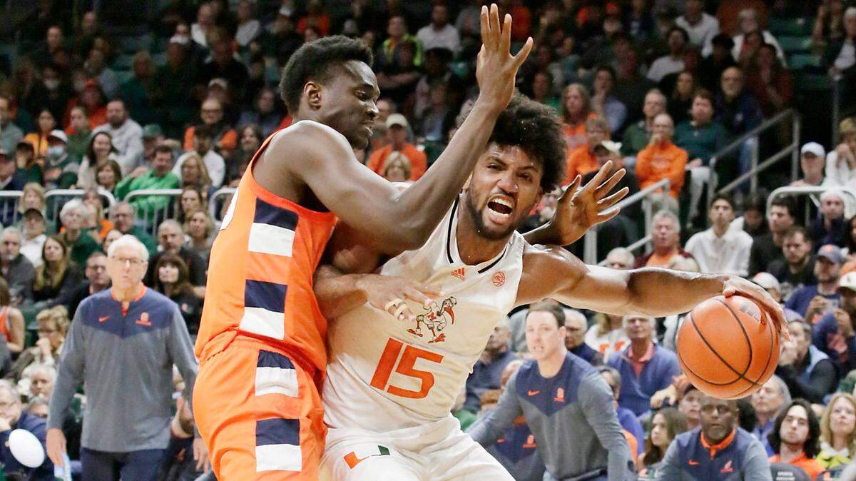UM Hurricanes Norchad Omier (15) slides around Syracuse Orange guard during NCAA men’s basketball game on Monday, January 16, 2023 at Watsco Center in Coral Gables. Andrew Uloza / for Miami Herald