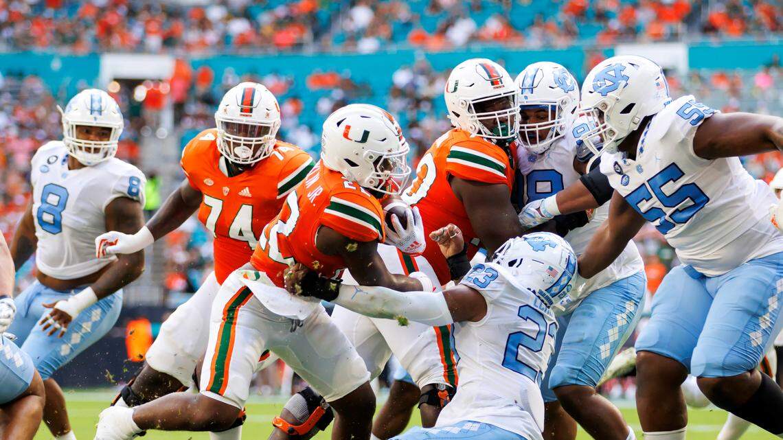 Miami Hurricanes running back Thaddius Franklin Jr. (22) runs with the football North Carolina Tar Heels linebacker Power Echols (23) during the second quarter of an ACC conference football game at Hard Rock Stadium on Saturday, October 8, 2022 in Miami Gardens, Florida..