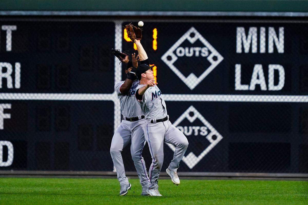Miami Marlins’ Joey Wendle, right, and Bryan De La Cruz collide as they attempt to catch a ball hit by Philadelphia Phillies’ Alec Bohm during the first inning of a baseball game Tuesday, Aug. 9, 2022, in Philadelphia. De La Cruz was charged with an error, and Bohm reached second.