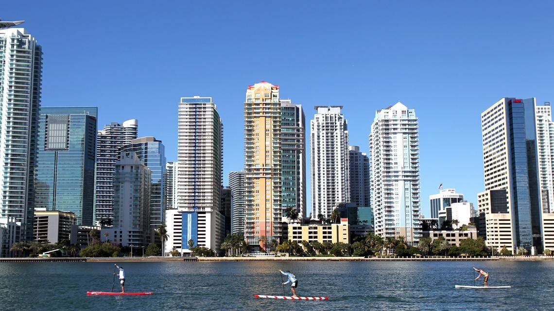 Miami ranked as the third metro area with the highest year-over-year increase in residential sales in the country, according to the RE/MAX National Housing report. Above: Racers paddle with the Brickell skyline in the background during the Orange Bowl Paddle Championship in Miami on Sunday, January 15, 2012. 