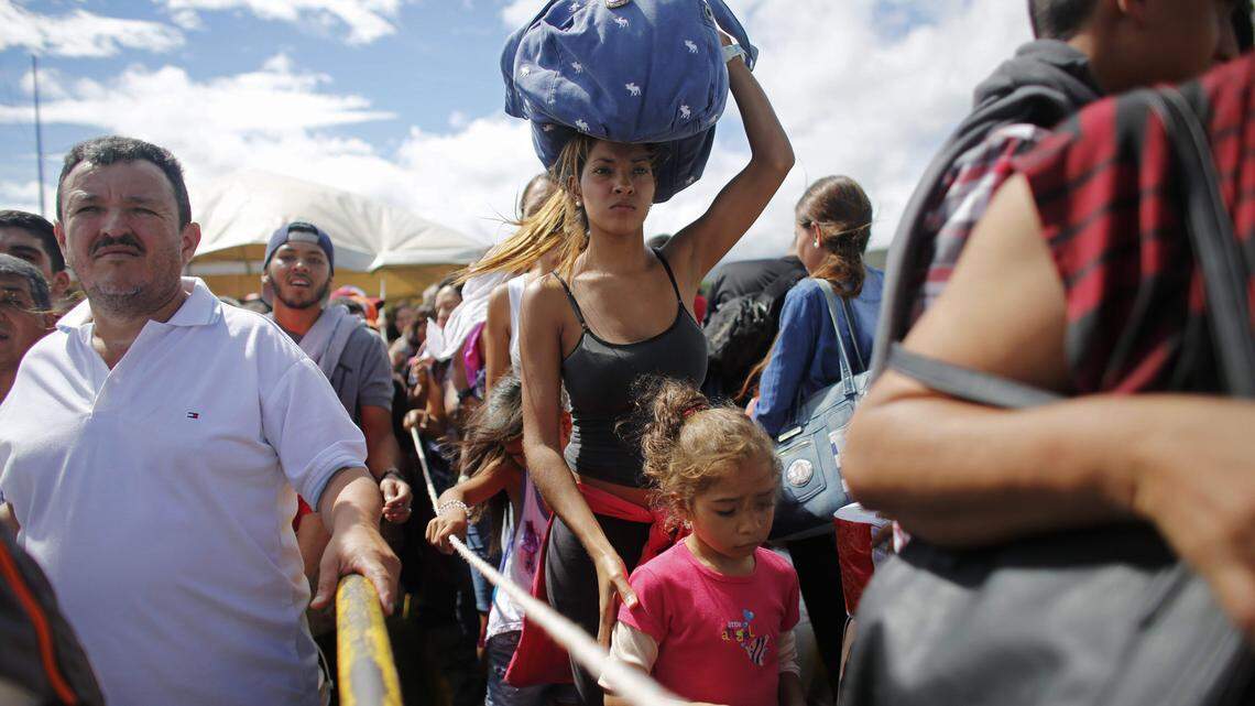 A woman carrying a bundle on her head waits in line in 2016 to cross the border into Colombia through the Simon Bolivar International Bridge in San Antonio del Tachira, Venezuela, joining thousands of Venezuelans who crossed the border into Colombia each day.