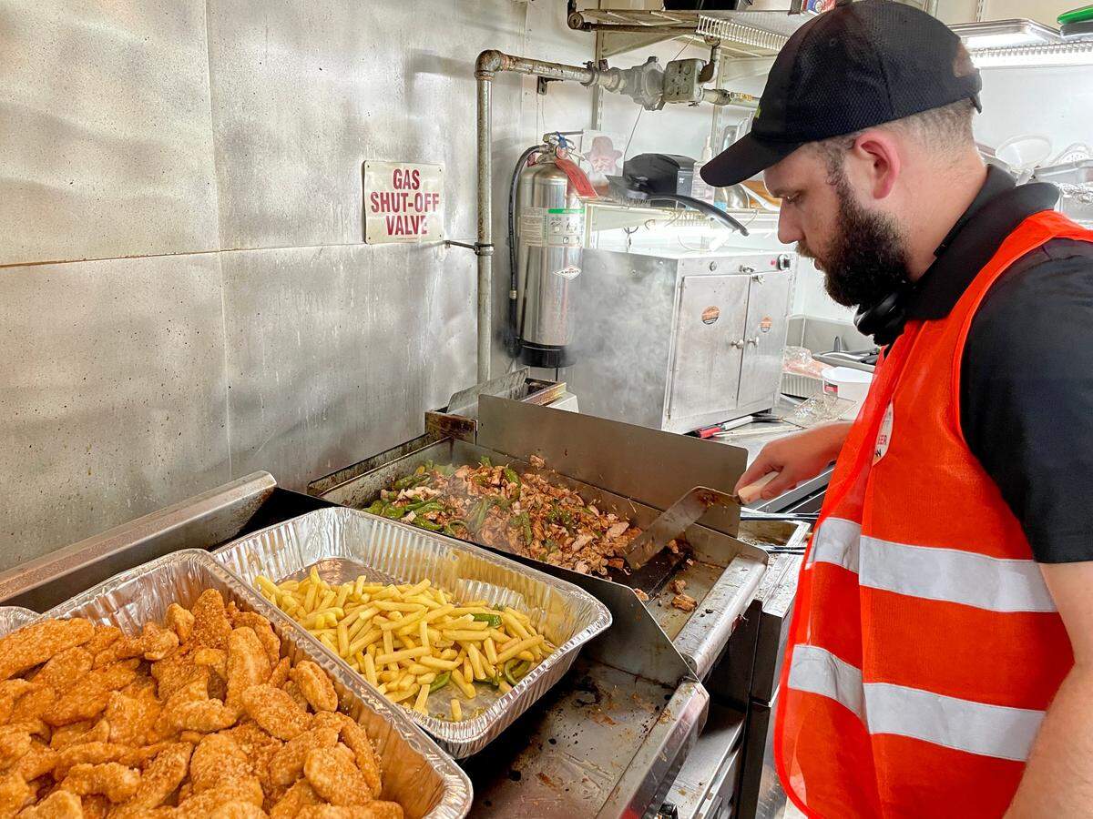 Jordan Brookmyer, a volunteer who was visiting from Baltimore, cooks chicken fajitas for kosher meals being made at the Surfside Community Center.