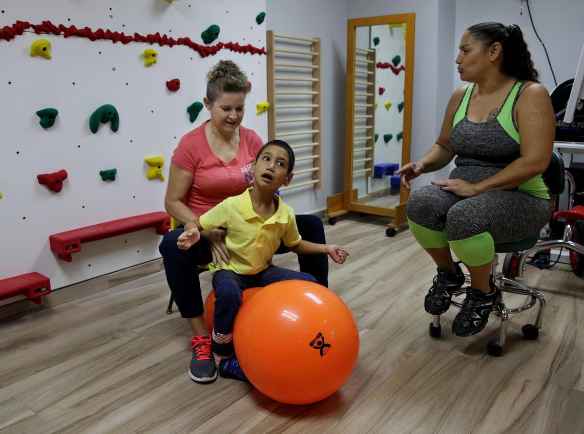 Brenda López talks to physical therapist Ana Lebrón during her son Angel Torres’ therapy appointment. Angel has cerebral palsy and his mother has pushed to make sure he gets the education he needs after Hurricane Maria.