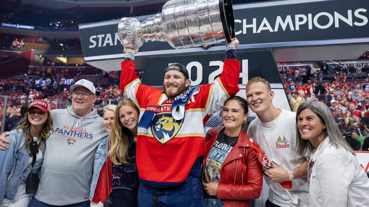 Florida Panthers left wing Matthew Tkachuk (19) lifts the Stanley Cup surrounded by his family after defeating the Edmonton Oilers in Game 7 of the Stanley Cup Final at Amerant Bank Arena on Monday, June 24, 2024, in Sunrise, Fla.