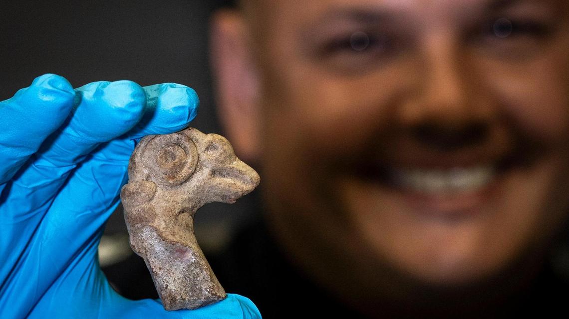Customs and Border Protection Officer Juan Esteves holds a terra cotta animal head at a Thursday, Sept. 14, 2023 ceremony in Miami, Florida. This is one of three artifacts the U.S. is repatriating to Costa Rica.