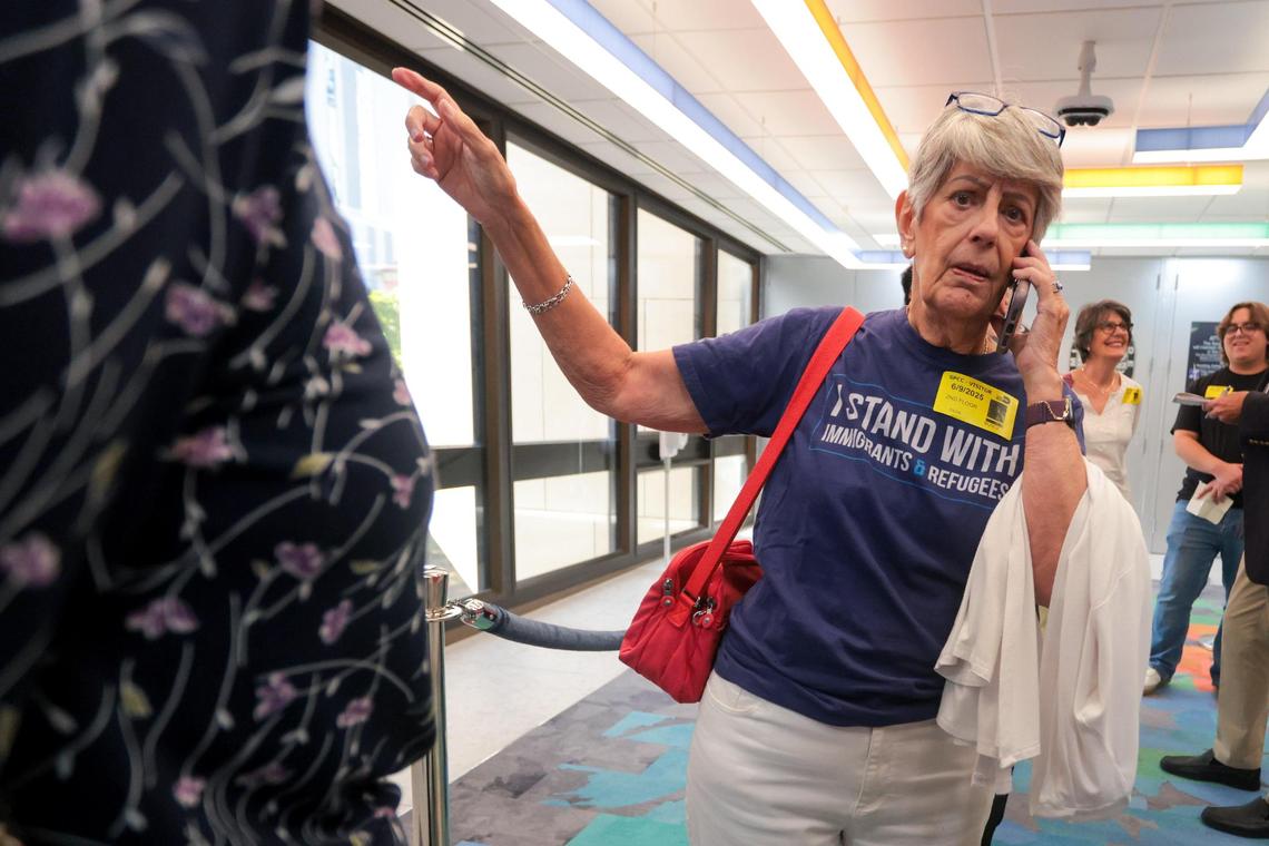 Silvia Muñoz, a volunteer with the Cuban American Women Supporting Democracy group, signals while talking on the phone as the leaves the commission chambers after the cancellation of a County Commission committee hearing to discuss a proposed agreement between ICE and the administration of Mayor Daniella Levine Cava on Monday, June 9, 2025.