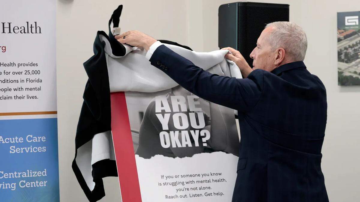 Henderson Behavioral Health CEO Steven Ronik unveils a poster during a news conference to announce an “Are You OK?” suicide prevention campaign in league with the South Florida Regional Transportation Authority, operator of Tri-Rail.