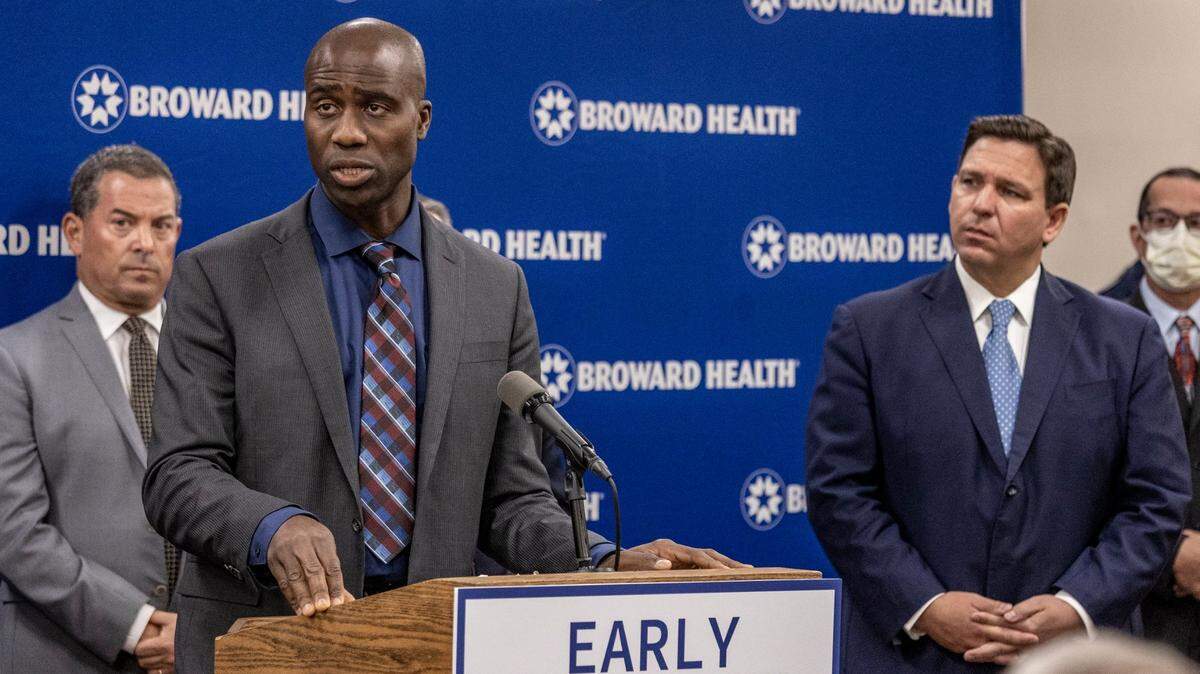 Florida Surgeon General, Joseph Ladapo, left, speaks during a press conference at Broward Health Medical Center on Jan. 3, 2022, as Gov. Ron DeSantis , right, listens. On Friday, Nov. 22, 2024, Ladapo called on local governments to halt adding fluoride to their water systems, citing health concerns. Many medical groups dismiss those concerns and say fluoride is key to preventing severe dental problems in children.