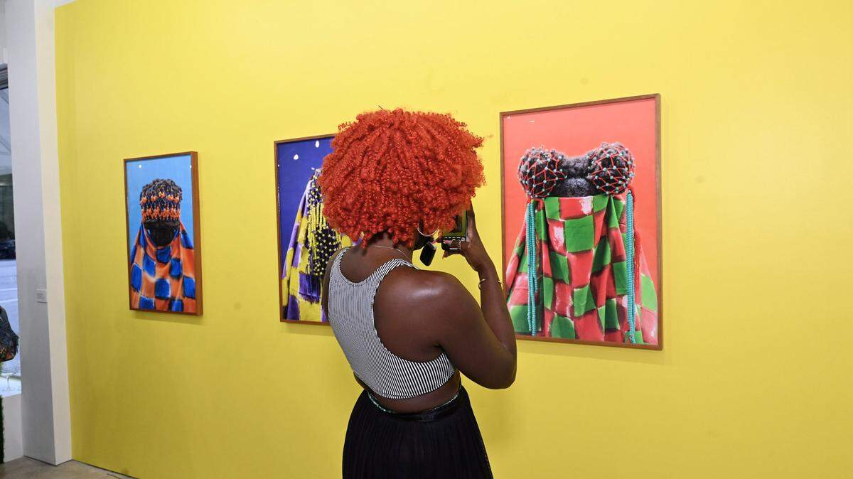 A visitor takes a photo of “Shake EM,” a series of portraits by artist Stephanie J. Woods, at “Depth of Identity: Art as Memory and Archive,” an art exhibition at Green Space Miami. The exhibition is on display until Oct. 20.
