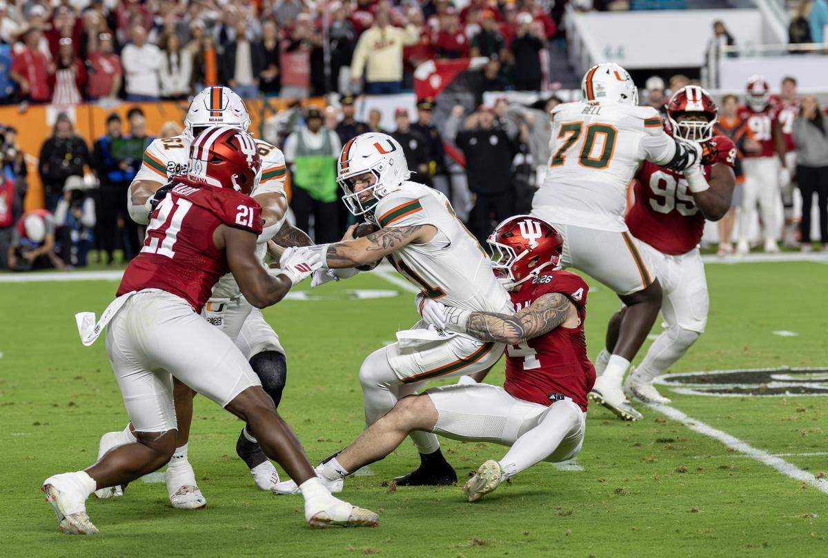 El quarterback de los Huracanes, Carson Beck (11,) es derribado por el linebacker de los Hoosiers de Indiana, Aideen Fisher, en el partido por la corona del football universitario celebrado el 19 de enero de 2026 en el Hard Rock Stadium en Miami Gardens, Florida.