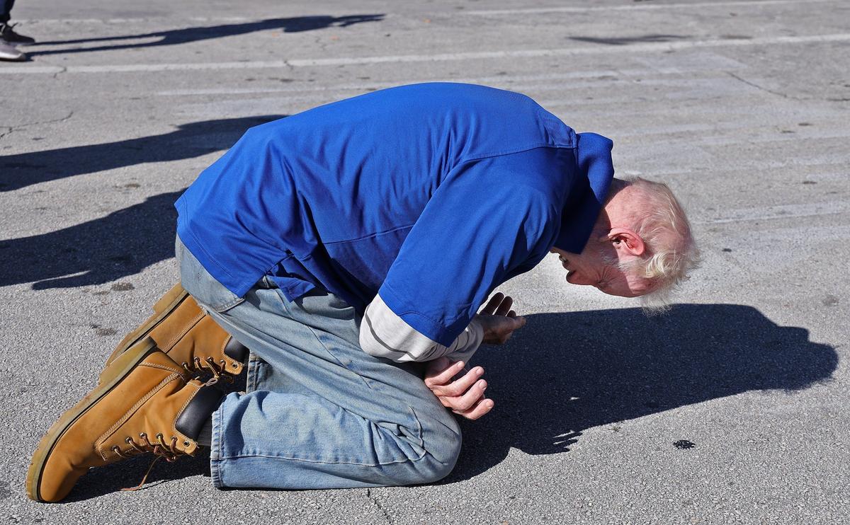Daniel Cahill, 73, credits his faith for staying clean from drugs for the past 37 years. Cahill kneels and bows his head after being overtaken by the gospel music of the Regeneration Mission band during “The Great Thanksgiving Day Banquet.” Thousands of Thanksgiving meals were served to the hungry and homeless in Miami-Dade and Broward counties on Thanksgiving Day with the help from 400 volunteers during an outside block party and outreach effort.