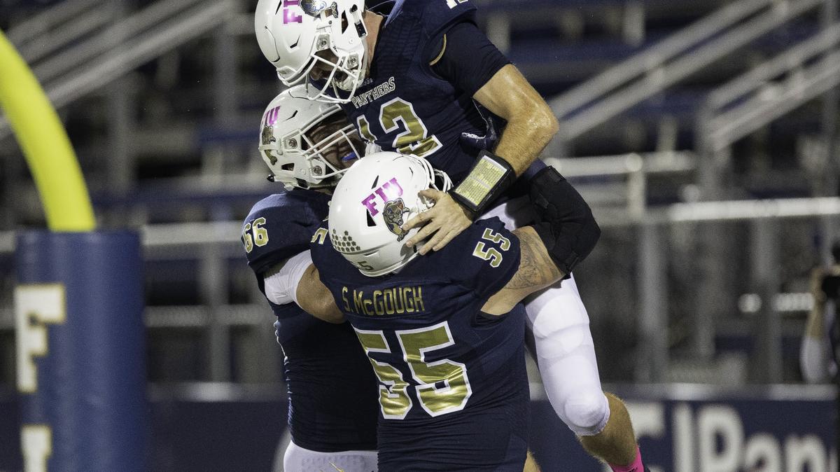 FIU guard Jordan Budwig (66) and offensive lineman Shane McGough (55) pick up quarterback James Morgan (12) after he rushed for a touchdown in the fourth quarter against Rice University at Riccardo Silva Stadium in Miami, FL, on Saturday, October 20, 2018.