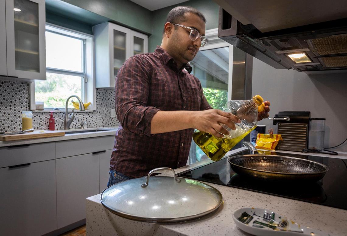 Eager to grow their family, Tanjim Hossain and his wife, Christine Oliver, hope to buy a larger house in their North Miami neighborhood. Hossain starts dinner in the kitchen.