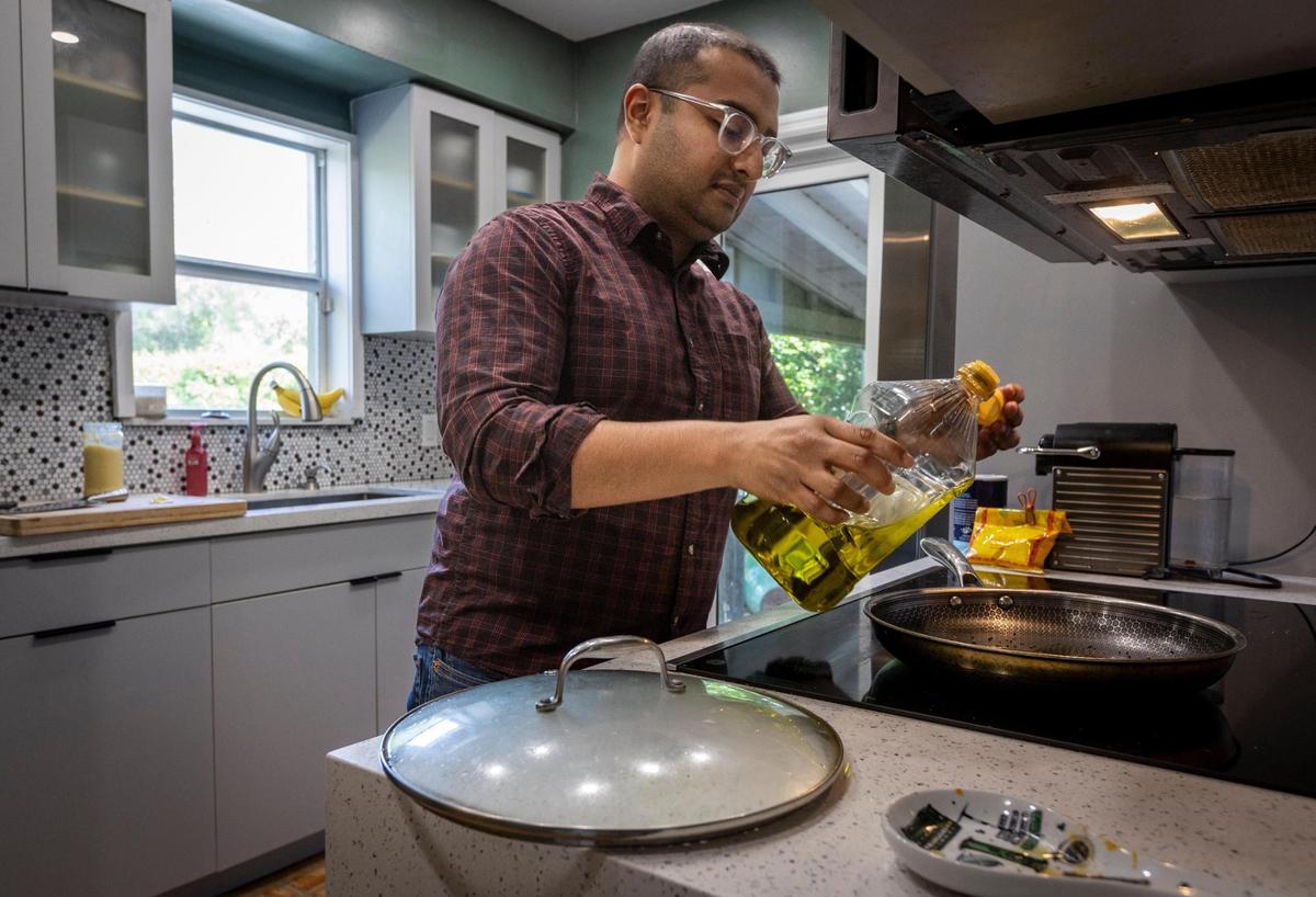 Ansiosos por aumentar su familia, Tanjim Hossain y su esposa, Christine Oliver, esperan comprar una casa más grande en North Miami antes de tener otro hijo. Tanjim Hossain empezando a cenar en la cocina el 22 de marzo de 2023.