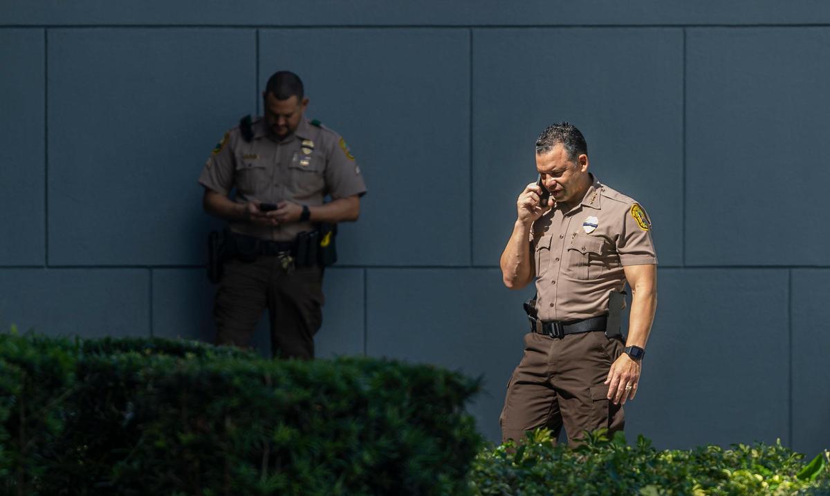 Miami-Dade Police Department Director Alfredo “Freddy” Ramirez, right, talks on the phone outside of Jackson Memorial Hospital’s Ryder Trauma Center on Friday, Nov. 4, 2022, in downtown Miami, Fla. Police say an off-duty officer was rushed to the hospital after his ex-girlfriend shot him in the head during a domestic dispute Friday morning in Hialeah.