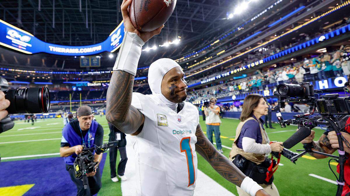 Miami Dolphins quarterback Tua Tagovailoa (1) raises the game ball after the Dolphins defeat the Los Angeles Rams during their NFL football game at SoFi Stadium in Inglewood, California on Monday, November 11, 2024.