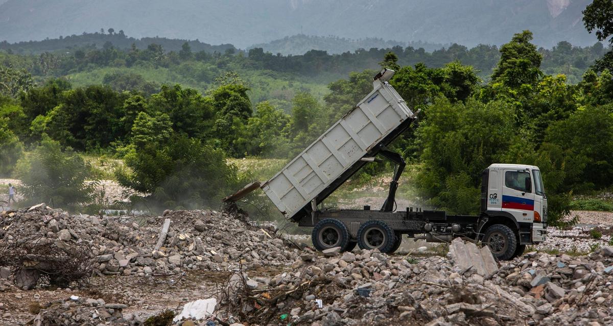 A dump truck dumps earthquake rubble on Monday, Aug. 23, 2021, in an empty field in Maniche as the cleanup begins after the Aug. 14 earthquake.