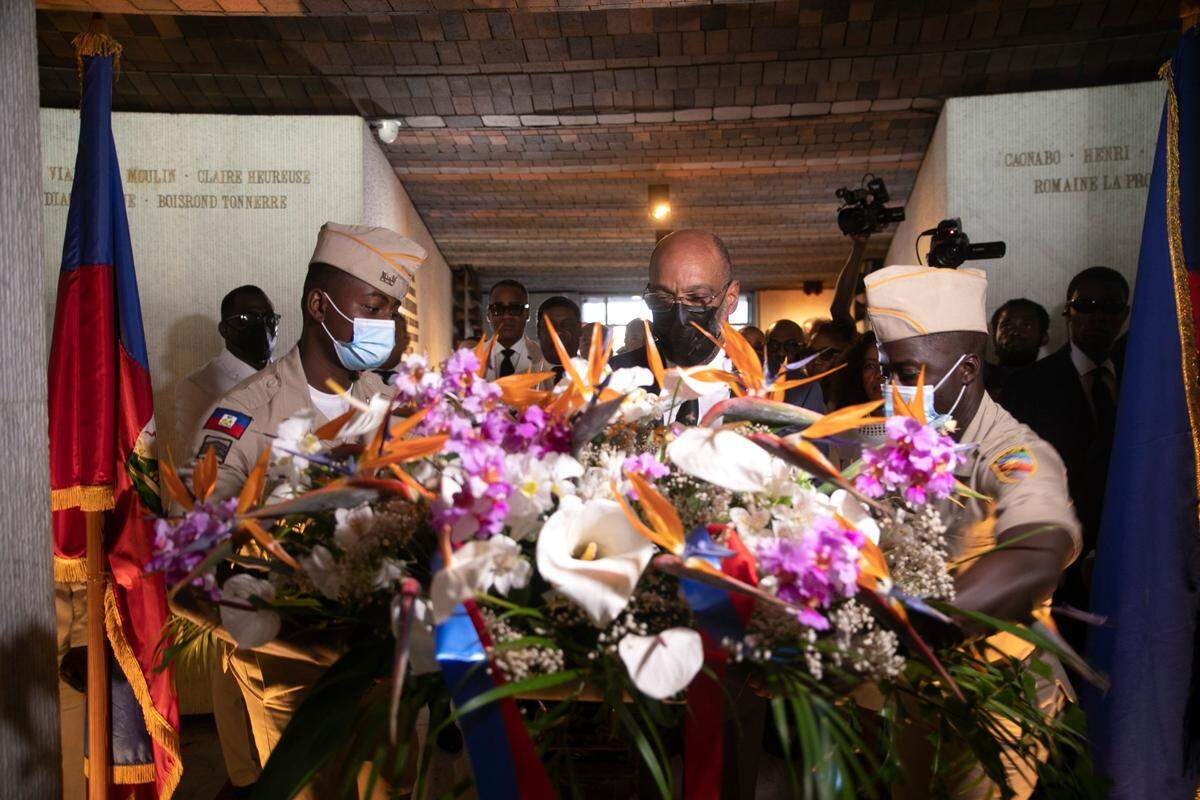 Haitian Prime Minister Ariel Henry, center, places flowers during a ceremony marking the death anniversary of revolutionary leader Jean-Jacques Dessalines at the National Pantheon Museum in Port-au-Prince, Haiti, Monday, Oct. 17, 2022.