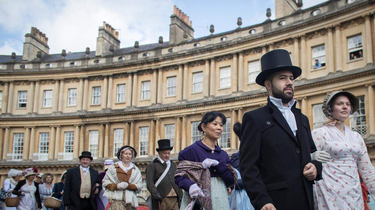 Participants in the annual Jane Austen Regency Costumed Parade walk past the Circus in the city centre on September 9, 2017 in Bath, England. T