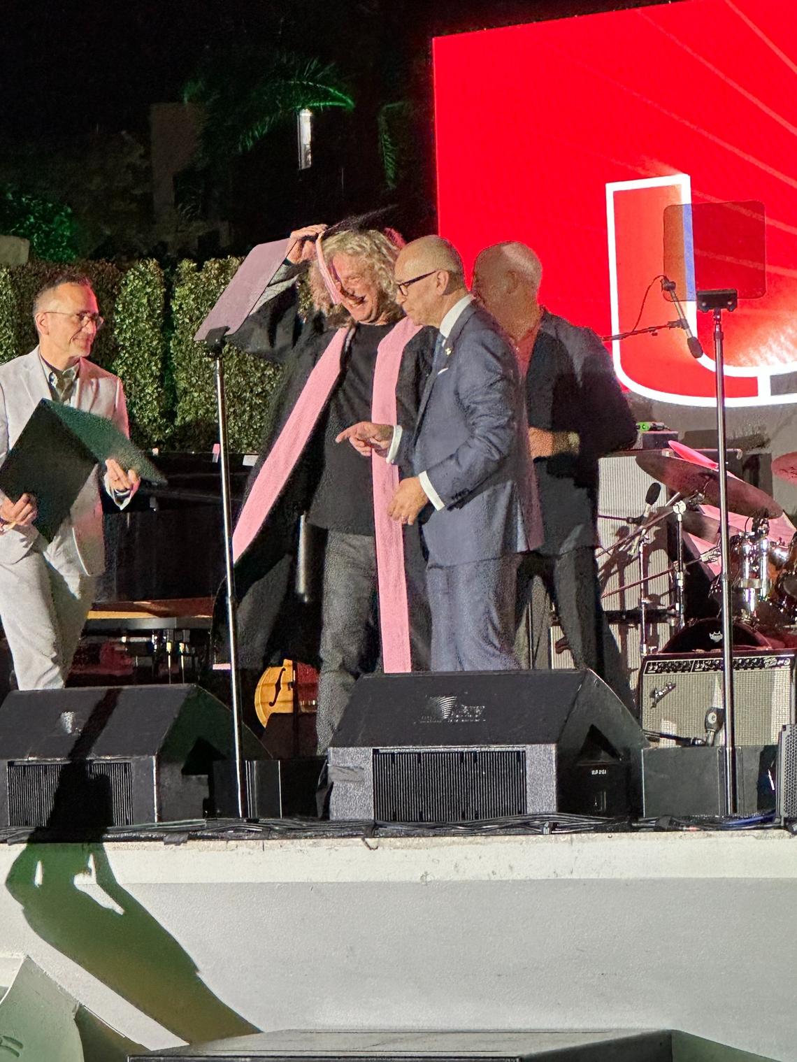 Jazz guitarist and UM alum Pat Metheny (center) receives an honorary doctorate in music from University of Miami President Joe Echevarria (right) and Frost School of Music Dean Shelly Berg (right, behind Echevarria) at U 100 Centennial Celebration event on April 8, 2025.