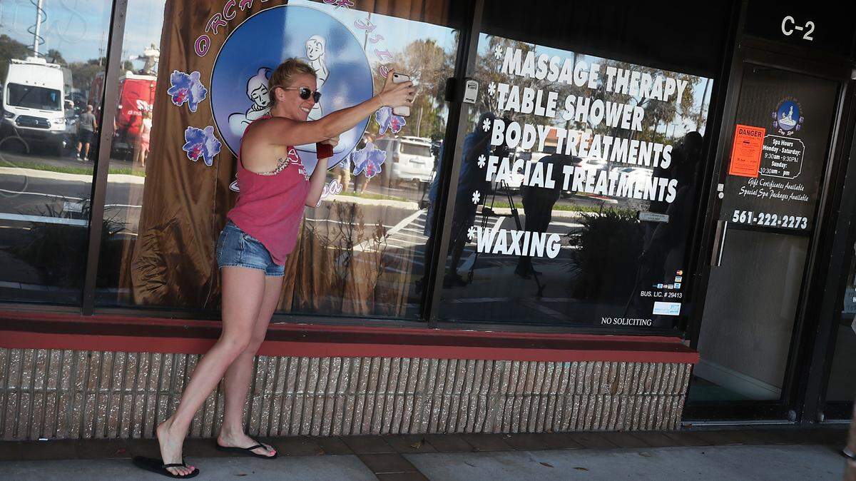 A woman takes a selfie near the front door of the Orchids of Asia Day Spa in Jupiter after New England Patriots owner Robert Kraft was charged with allegedly soliciting for sex on February 22, 2019.