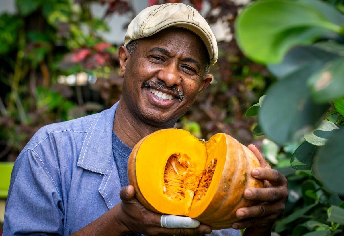 Chef Jerry Dominique, who has made soup joumou a regular item on his KC Healthy Cooking restaurant’s menu, holds a pumpkin, the main ingredient in the popular Haitian soup.