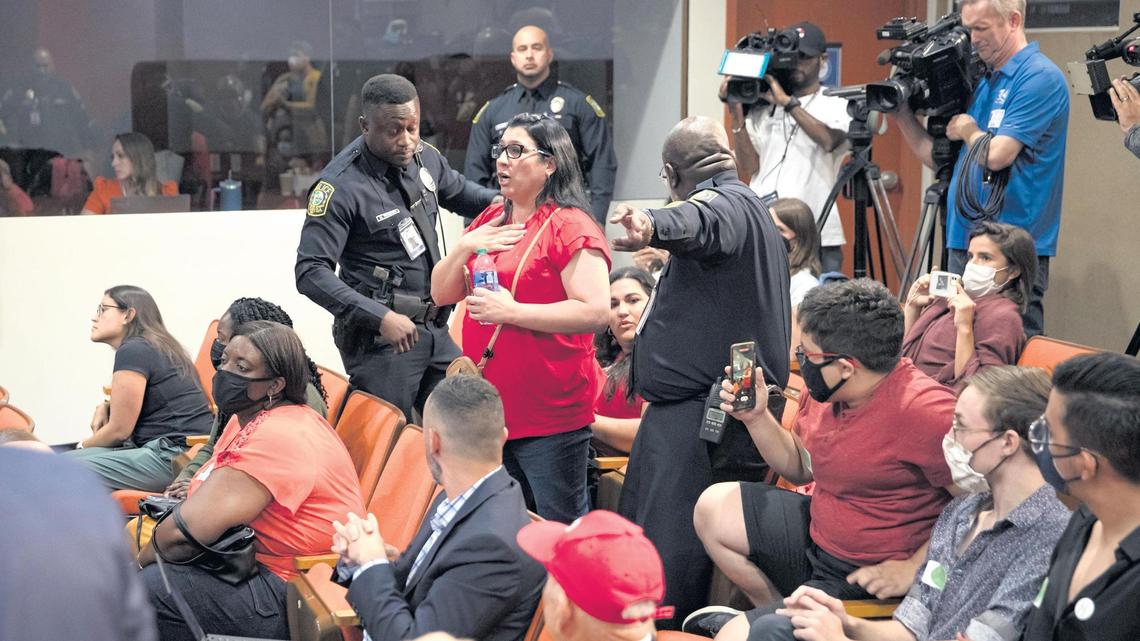 A woman is escorted out by police at the Miami-Dade County School Board meeting on Wednesday, July 20, 2022, in Miami, Florida. Parents and community members spoke during a heated discussion over whether the School Board should adopt the sexual health education textbook “Comprehensive Health Skills” for middle and high school students in Miami-Dade County Public Schools. In a 5-4 vote, the Board decided not to adopt the textbook, a move that leaves the district with no sexual education curriculum for at least four to eight months.