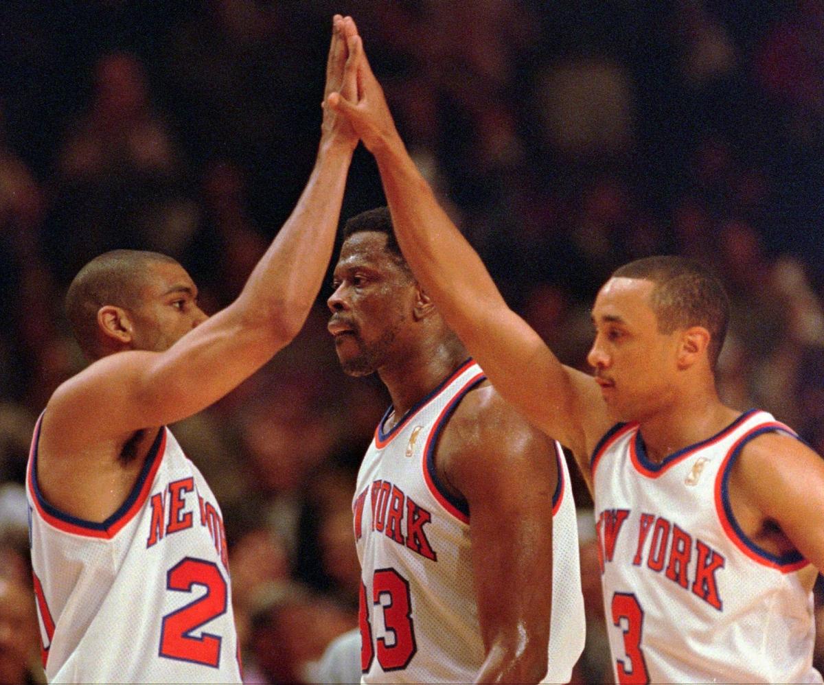 New York Knicks teammates Allan Houston, left, and John Starks, right, do the high five as center Patrick Ewing, center, walks behind them during the second quarter of their Eastern Conference semifinal game against the Miami Heat Monday, May 12, 1997 at Madison Square Garden in New York. (AP Photo/Kathy Willens)