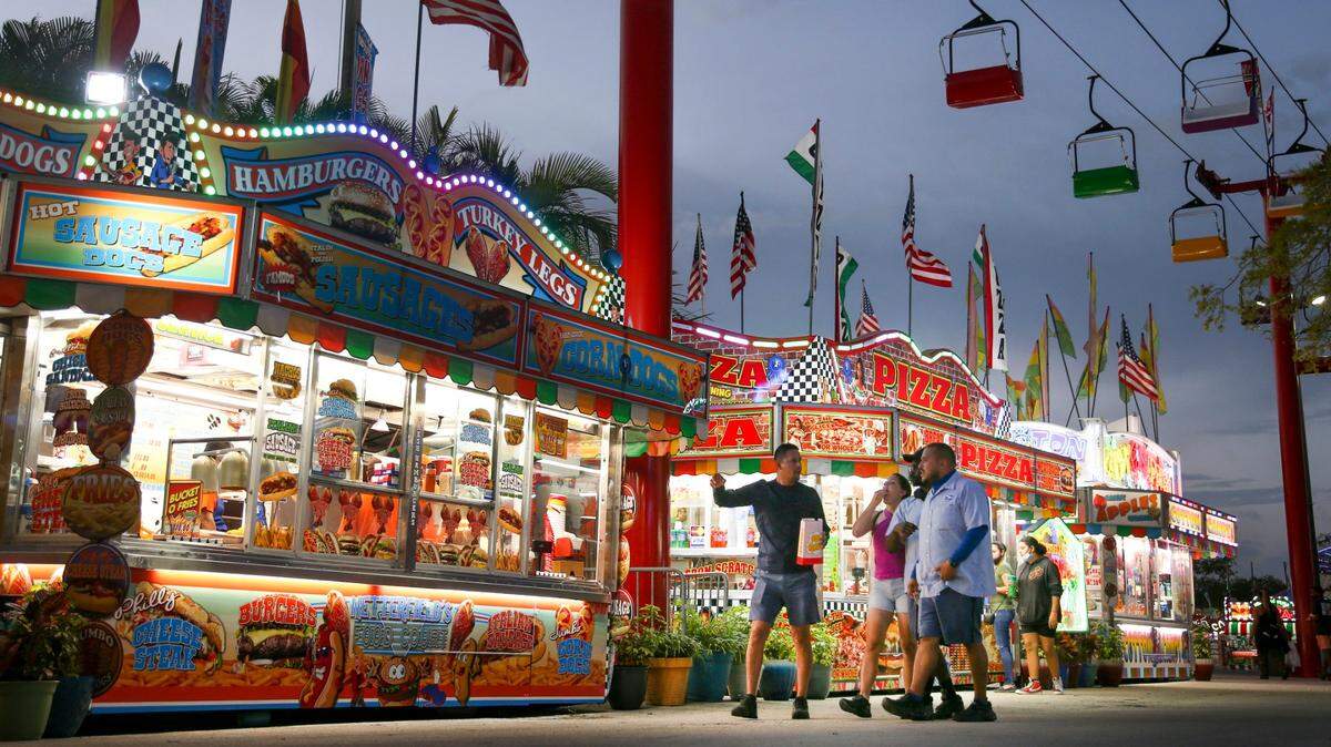 Fairgoers walk by the concession stands during the opening day of the Miami-Dade County Youth Fair at the Miami-Dade Fair & Expo Center in Miami, Florida, on Thursday, March 17, 2022.