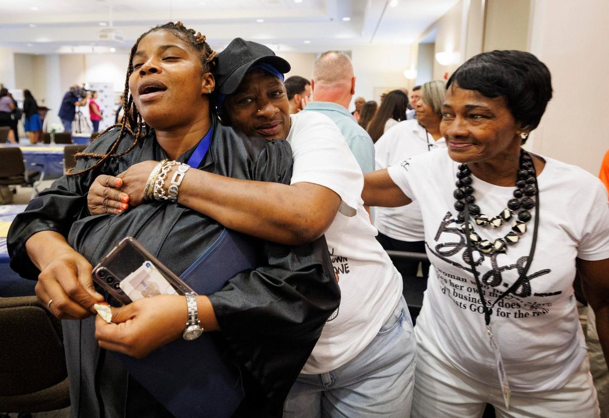 Dakisha Hamilton, left, receives a surprise hug from family and friends after her graduation ceremony for the Hotel Property Specialist program on Wednesday, Sept. 11, 2024, at Camillus House in Miami.