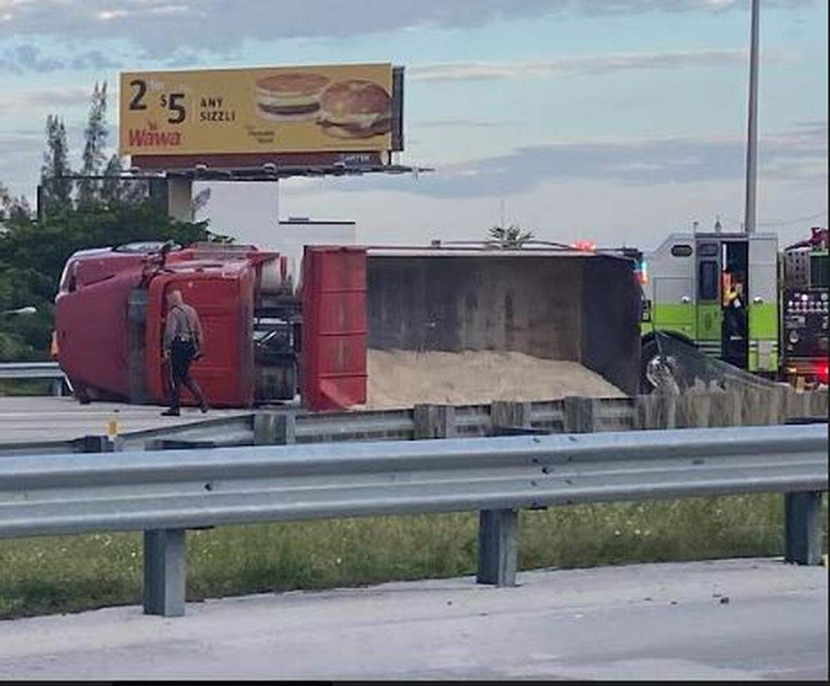 A state trooper walks toward the driver of the truck, who’s on the ground just outside the photo after being ejected during the crash.
