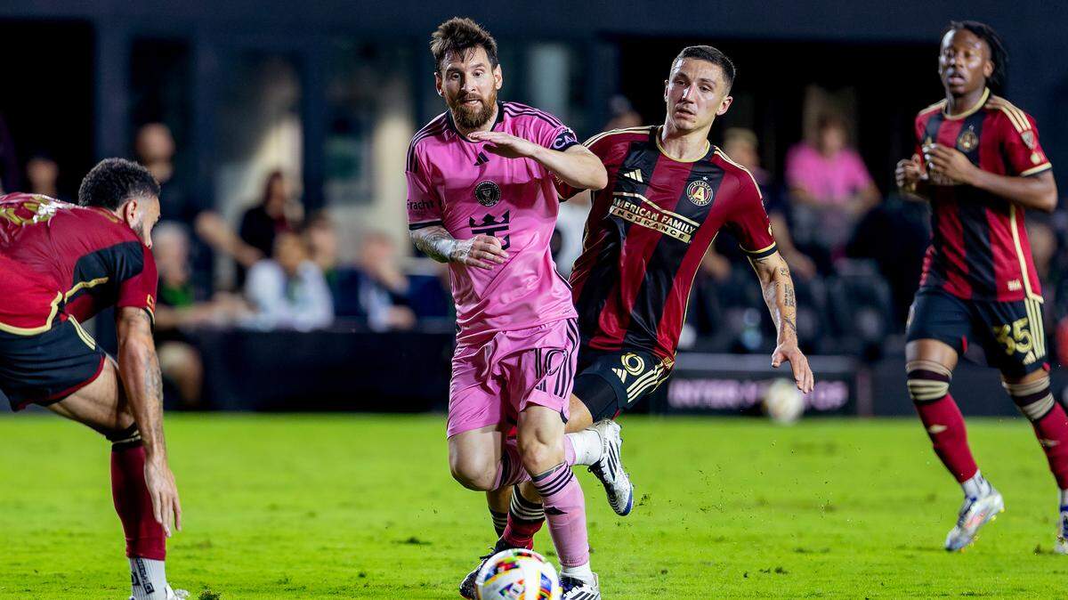 El delantero del Inter Miami Lionel Messi corre con el balón mientras el defensor del Atlanta United Derrick Williams (izq.) y el mediocampista Bartosz Slisz (6) defienden, en la segunda mitad del tercer partido de la serie de playoffs de la MLS celebrado el 9 de noviembre de 2024 en el Chase Stadium en Fort Lauderdale, Florida.