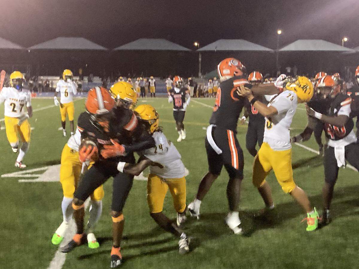Killian defenders bring down Carol City running back Justin Compere after a short gain during Friday’s Region 4-2A quarterfinal playoff at Betty Ferguson Park in Miami Gardens, Fla.