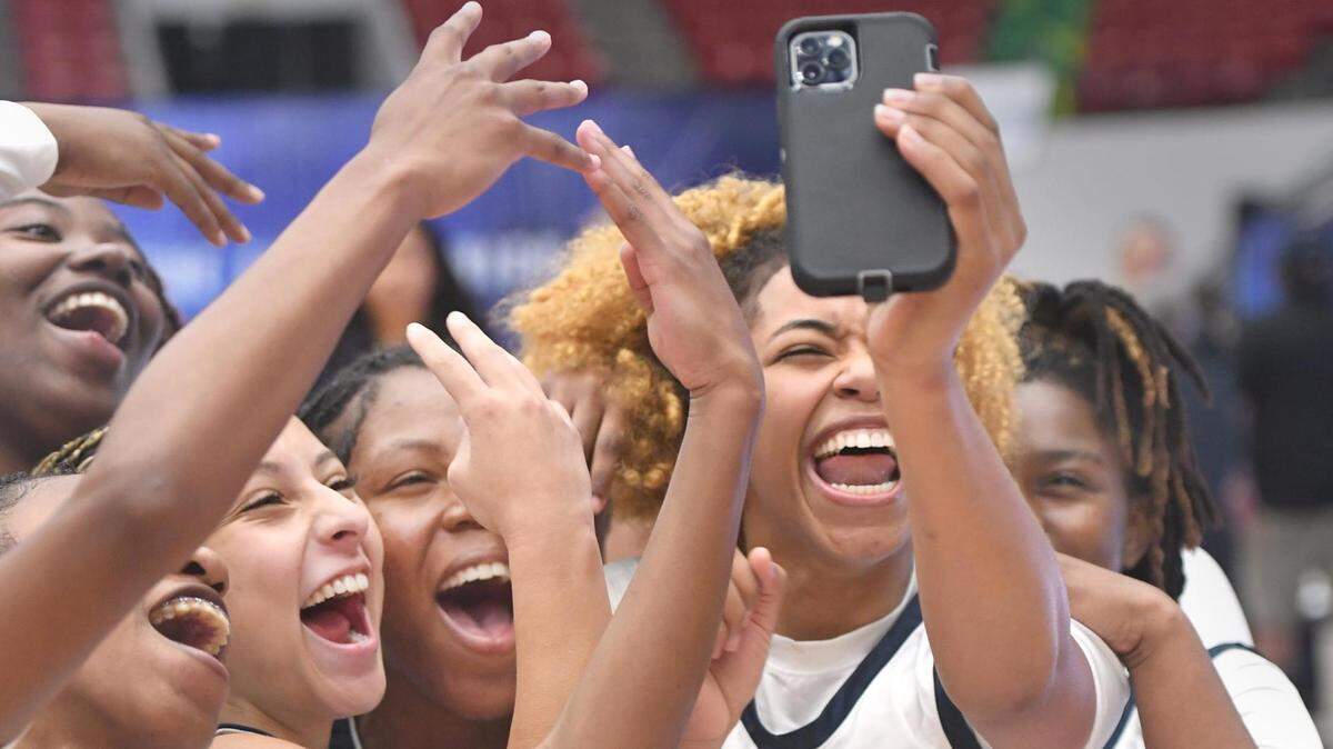 St. Thomas Aquinas players celebrate on a live feed after beating Bloomingdale in the Class 6A final during the Florida High School State Championships at the RP Funding Center in Lakeland, Fl on Friday March 8, 2024. St. Thomas defeated Bloomingdale 70-35. Scott Wheeler | Photo