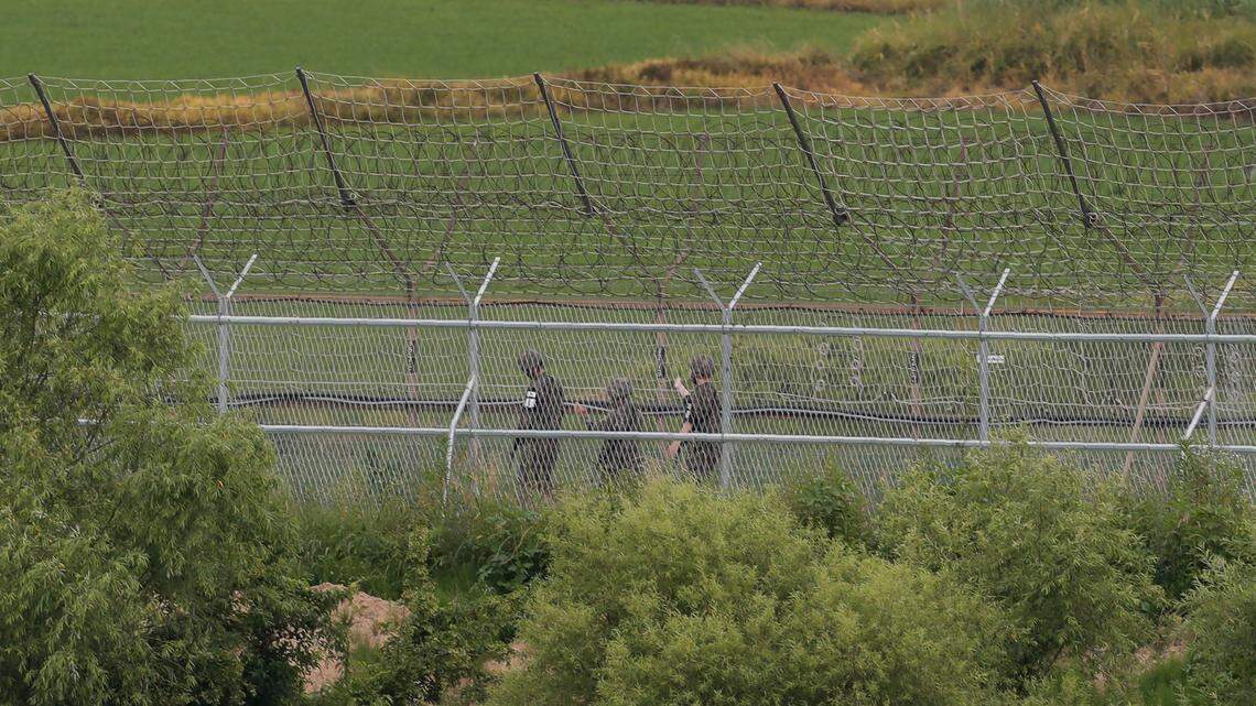 South Korean army soldiers patrol along a barbed-wire fence in Paju, South Korea, near the border with North Korea in June. A former gymnast from North Korea told South Korean security forces he vaulted a 10-foot border fence topped with barbed wire Nov. 4 to defect, authorities say.
