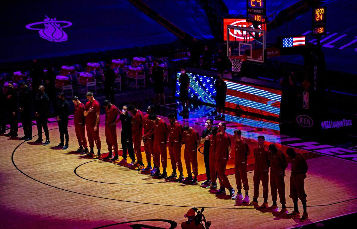 Miami Heat players listen to the American national anthem before the start of a NBA basketball game against the New Orleans Pelicans on Christmas Day at the AmericanAirlines Arena on Friday, December 25, 2020.