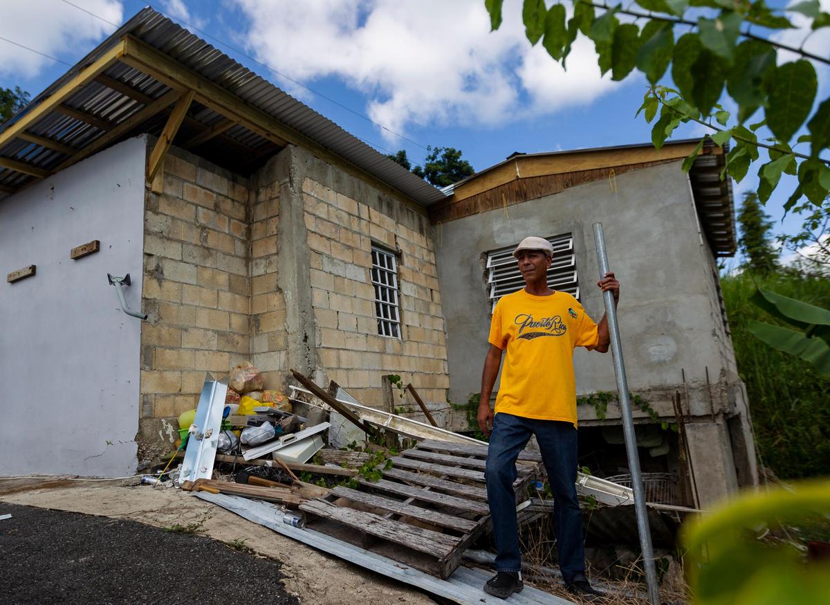 Fernando Rivera Molina, 60, stands outside his partially repaired home in the La Juncia community in Comero, Puerto Rico on August, 25, 2018. Volunteers helped Rivera Molina put on a new roof after he was twice denied federal aid because he lacked a deed to his property after Hurricane Maria.